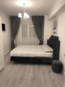 um quarto com uma cama e um lustre em SunSet Apartament em Oradea