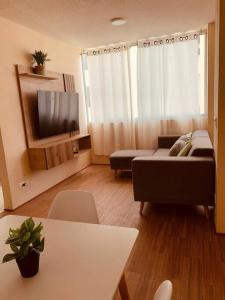 a living room with a couch and a tv at Departamento Piura in Piura