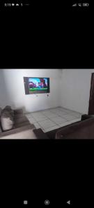 uma televisão numa parede branca num quarto em Casa de praia Jacumã em Conde