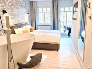 een slaapkamer met een bed en een bad in een kamer bij Ferienwohnung Lieblingssuite am Strand in Ahlbeck