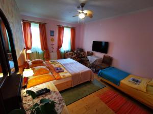 a bedroom with two beds and a living room at Katica Vendégház Somogyvár - Ladybird Villa Somogyvár in Somogyvár