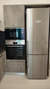 a kitchen with a stainless steel refrigerator and a microwave at Pearl Apartments in Sliema