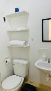a white bathroom with a toilet and a sink at Departamento Piura in Piura