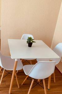 a white table and chairs with a potted plant on it at Departamento Piura in Piura