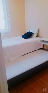 a white bed in a room with a window at Departamento Piura in Piura