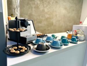 a counter with cups and saucers and a coffee maker at Butik Life Hotel & Apartments in Budapest