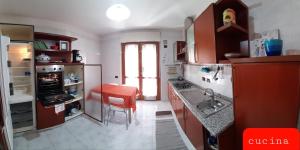 una cucina con armadi rossi e uno sgabello rosso di Marisa's Appartment in "The City of Sun" a Cagliari