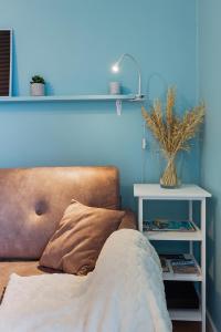niebieski pokój z kanapą i stołem z rośliną w obiekcie Joli studio - Parking Privé - WIFI Très Haut Débit - Au calme w mieście Nantes
