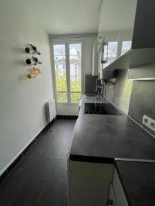 a kitchen with a black counter top and a window at Nice flat Paris 16 near to Eiffel Tower in Paris