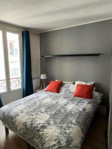 a bedroom with a bed with two red pillows at Nice flat Paris 16 near to Eiffel Tower in Paris