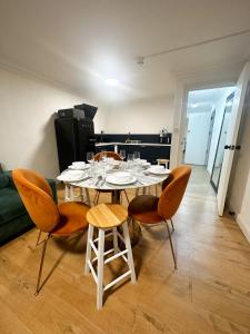 a dining room with a table and four chairs at Flat 4, Stay in Aldgate in London