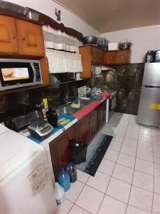 a kitchen with a sink and a stove at Mandy's Homestay in Couva
