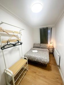 a small bedroom with a bed and a shelf at Flat 4, Stay in Aldgate in London