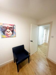 a room with a chair and a painting on the wall at Flat 4, Stay in Aldgate in London