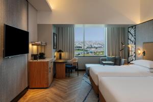 a hotel room with two beds and a flat screen tv at Sheraton Mall of the Emirates Hotel, Dubai in Dubai