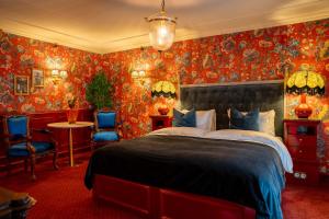 a bedroom with a large bed and red wallpaper at Charmante - Skostredet Hôtel in Bergen
