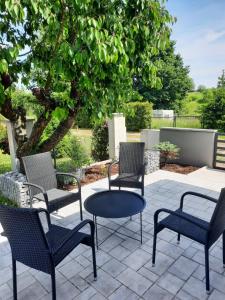 een patio met stoelen, een tafel en een boom bij bungalov na břehu Labe s vlastním molem in Pardubice