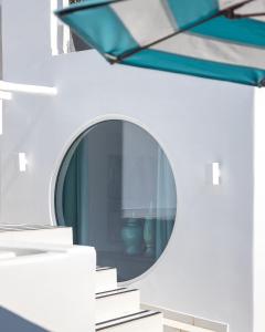a mirror on the side of a wall with books at Nammos Hotel Mykonos in Psarou
