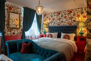 a bedroom with a blue bed and a couch at Charmante - Skostredet Hôtel in Bergen