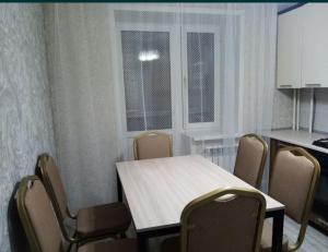 Habitación con mesa, sillas y cocina. en 3 комнатная квартира, en Uralsk