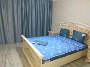 1 dormitorio con 1 cama grande y edredón azul en 3 комнатная квартира, en Uralsk