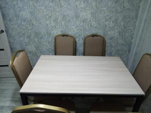 una mesa con 3 sillas en una habitación en 3 комнатная квартира, en Uralsk