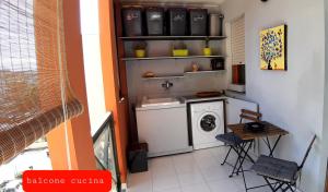 una lavanderia con lavatrice e tavolo di Marisa's Appartment in "The City of Sun" a Cagliari