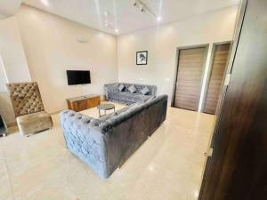 een woonkamer met een bank en een televisie bij Woodstock Villa Homestay Ranjit Avenue in Amritsar