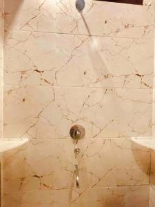 y baño con ducha y pared de mármol. en Woodstock Villa Homestay Ranjit Avenue, en Amritsar
