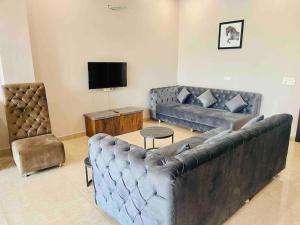 sala de estar con sofá grande y TV en Woodstock Villa Homestay Ranjit Avenue, en Amritsar