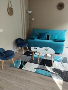 un soggiorno con divano blu e 2 tavoli di Le Valentin a Eaux-Bonnes