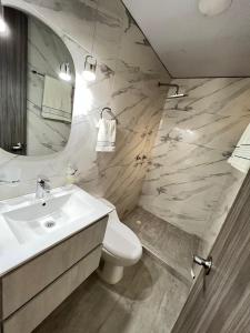 a bathroom with a sink and a toilet and a mirror at Apartamento completo en Pereira. in Pereira