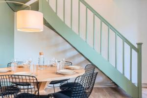 a dining room with a table and chairs under a staircase at 3 bedroom house with garden near Lille + garage in Lambersart +28 photos