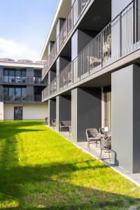 un edificio con sedie e un prato di fronte ad esso di Village by Maier - kontaktloser Check-in a Hohenems