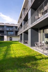 un edificio con panchine e un prato di fronte ad esso di Village by Maier - kontaktloser Check-in a Hohenems