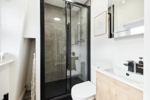 a bathroom with a shower and a toilet and a sink at The North Notting Hill Crib - Bright 1BDR Flat in London