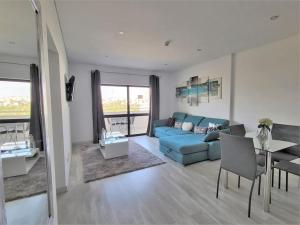 Una sala de estar con un sofá azul y una mesa. en AL Sunset, en Albufeira