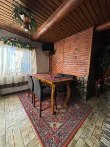 uma sala de jantar com uma mesa de madeira e cadeiras em Kotedzh Smereka em Kelechin