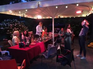 a group of people sitting at tables at a party at Guesthouse 'Blue House' in vintage villa&garden in Copenhagen