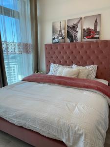 a large bed with a red headboard in a bedroom at Shared Ensuite BURJ Khalifa VIEW King Bedroom in 2Bed near Dubai Mall 8mins away in Dubai