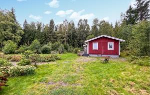 een rode schuur midden in een tuin bij Pet Friendly Home In Frgelanda With Kitchen in Färgelanda