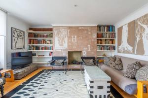 sala de estar con sofá y chimenea en Chic Top Floor Apartment in the heart of Notting Hill Ladbroke Grove en Londres