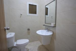 a white bathroom with a toilet and a sink at Dar Hashim Hotel Suites - Alnuzha in Riyadh