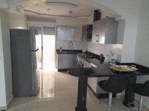 a kitchen with a black table and chairs in it at appartement mdiq tetouan, 2 chambres 1 double salon in M'diq