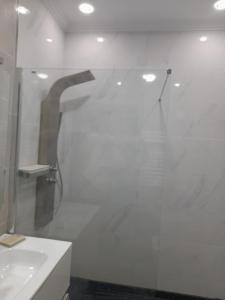 een witte badkamer met een douche en een wastafel bij appartement mdiq tetouan, 2 chambres 1 double salon in M'diq