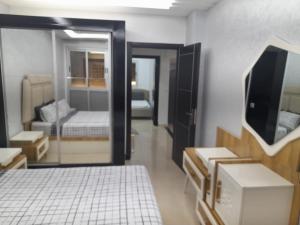 een kamer met een slaapkamer met een bed en een televisie bij appartement mdiq tetouan, 2 chambres 1 double salon in M'diq