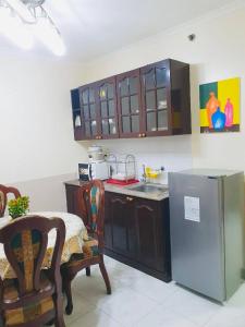 Il comprend une cuisine équipée d'un réfrigérateur, d'une table et de chaises. dans l'établissement BAGUIO CONDO ALBERGO HOTEL by DEI GRATIA, à Baguio