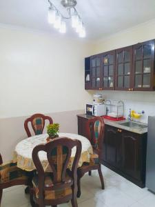 une cuisine avec une table et des chaises et une cuisine avec un comptoir dans l'établissement BAGUIO CONDO ALBERGO HOTEL by DEI GRATIA, à Baguio