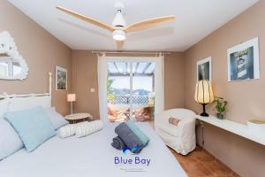 Un dormitorio con una cama blanca y un ventilador de techo. en Al Alba Townhouse with Community Pool and Padel, en La Herradura 56 fotos más