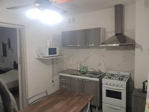 a small kitchen with a stove and a sink at Hospedaje Colonia in Colonia Caroya